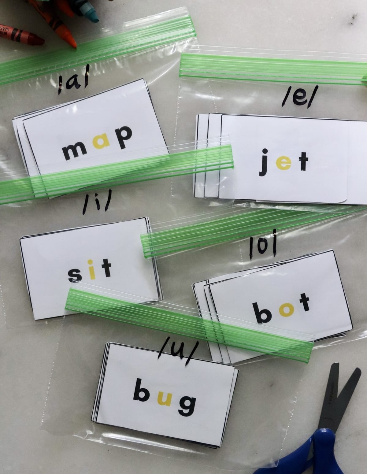 5 small zip lock bags with flashcards inside, separated by middle vowel sound. 