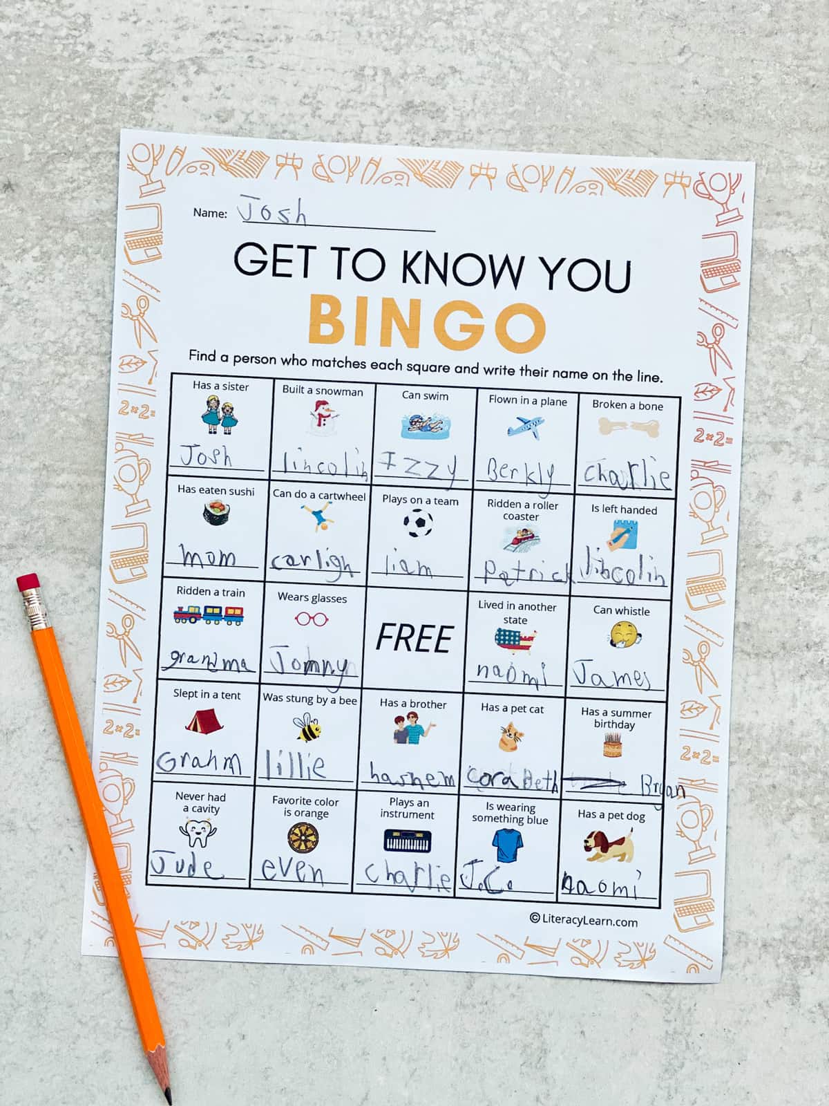 A completed bingo page and pencil, with each box filled in with names.
