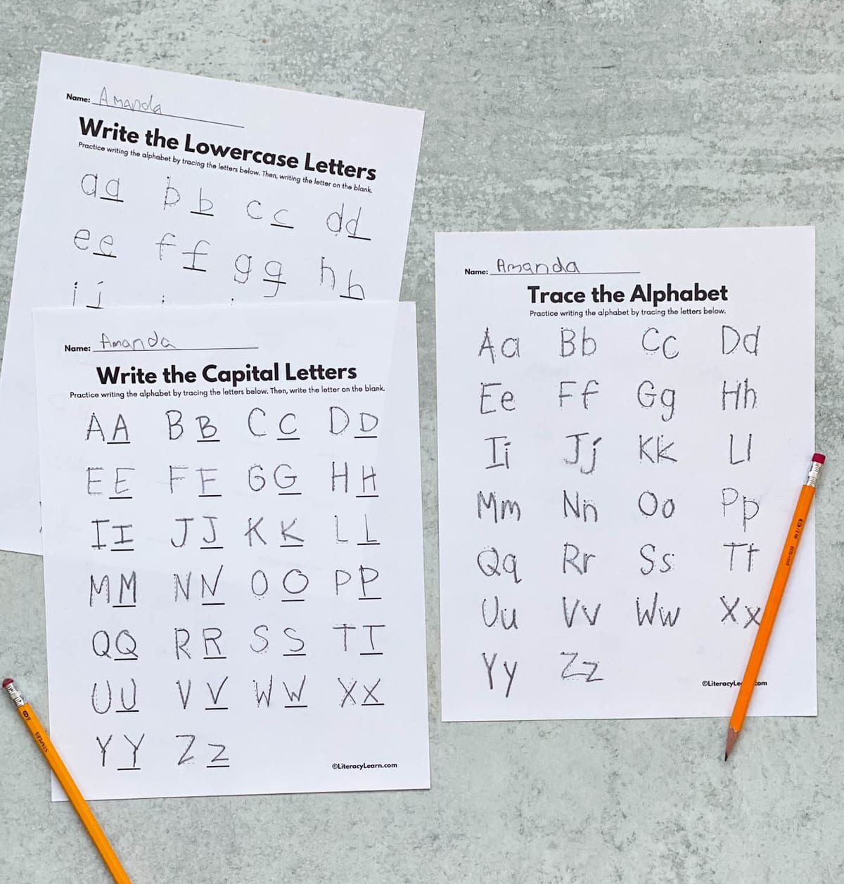 Three completed letter tracing worksheets with a pencil.