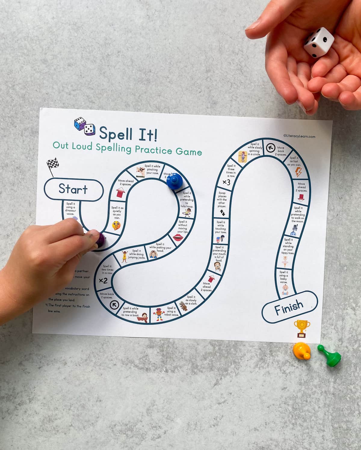 Two children's hands playing the spell it board game. 
