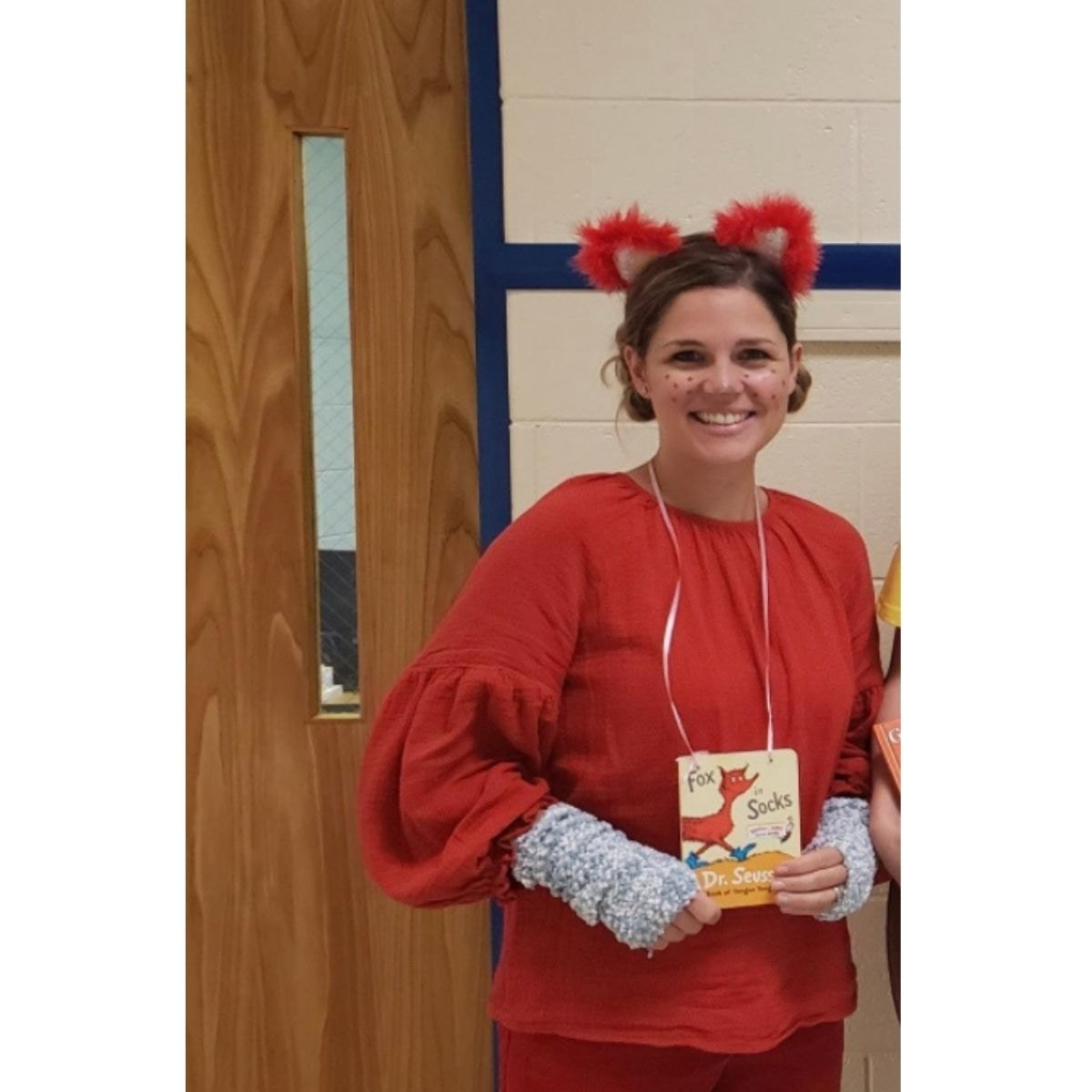 A photograph of Katie dressed in red as Fox in Socks costume for Halloween.