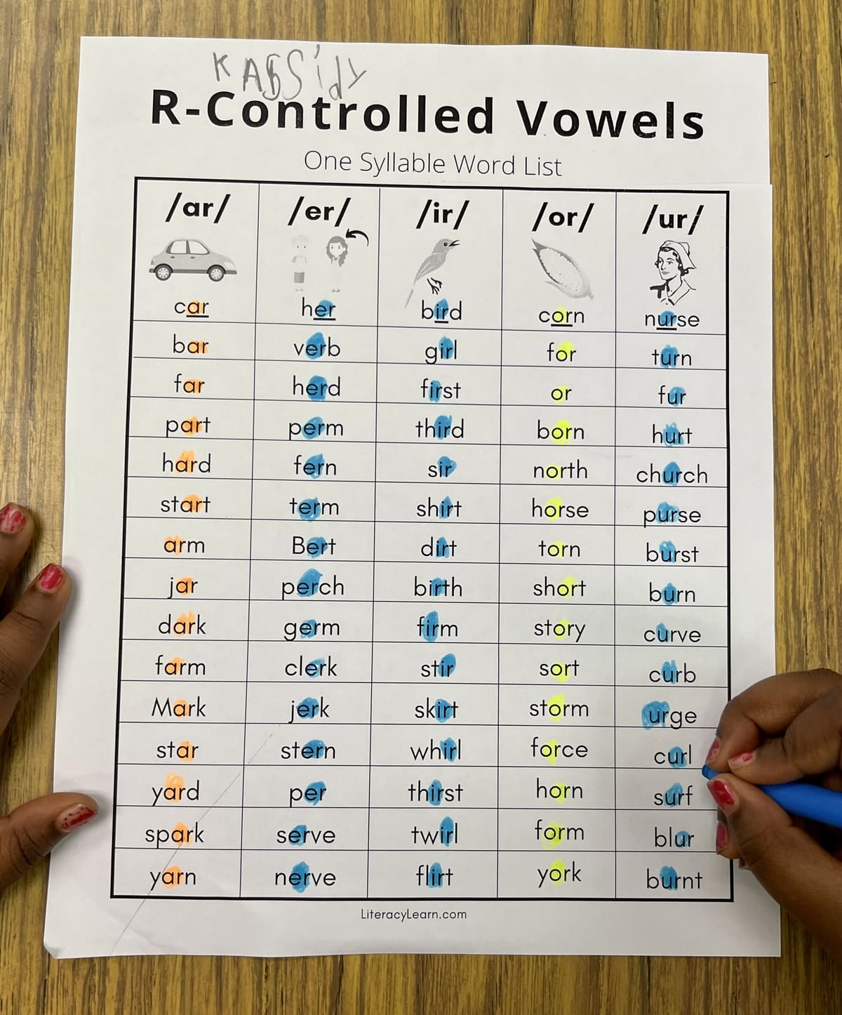 Photograph of student holding a highlighter marking the Bossy R one syllable words