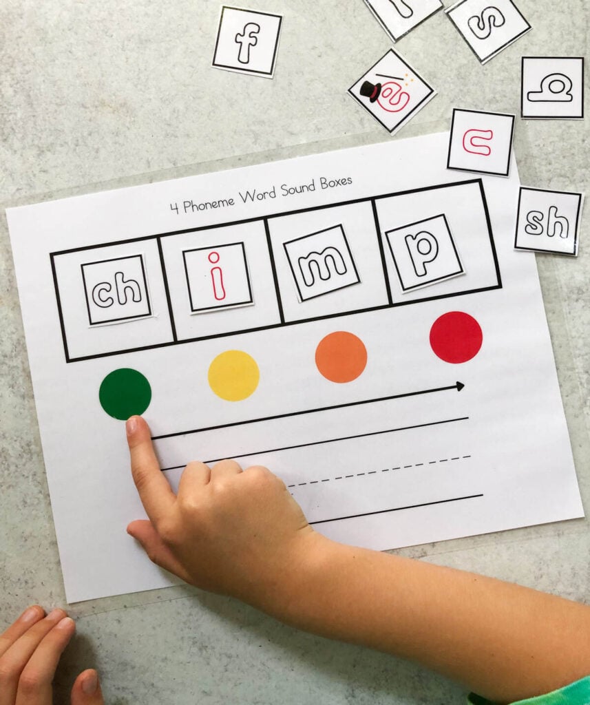 A child using a sound box worksheet to map the word "chimp."