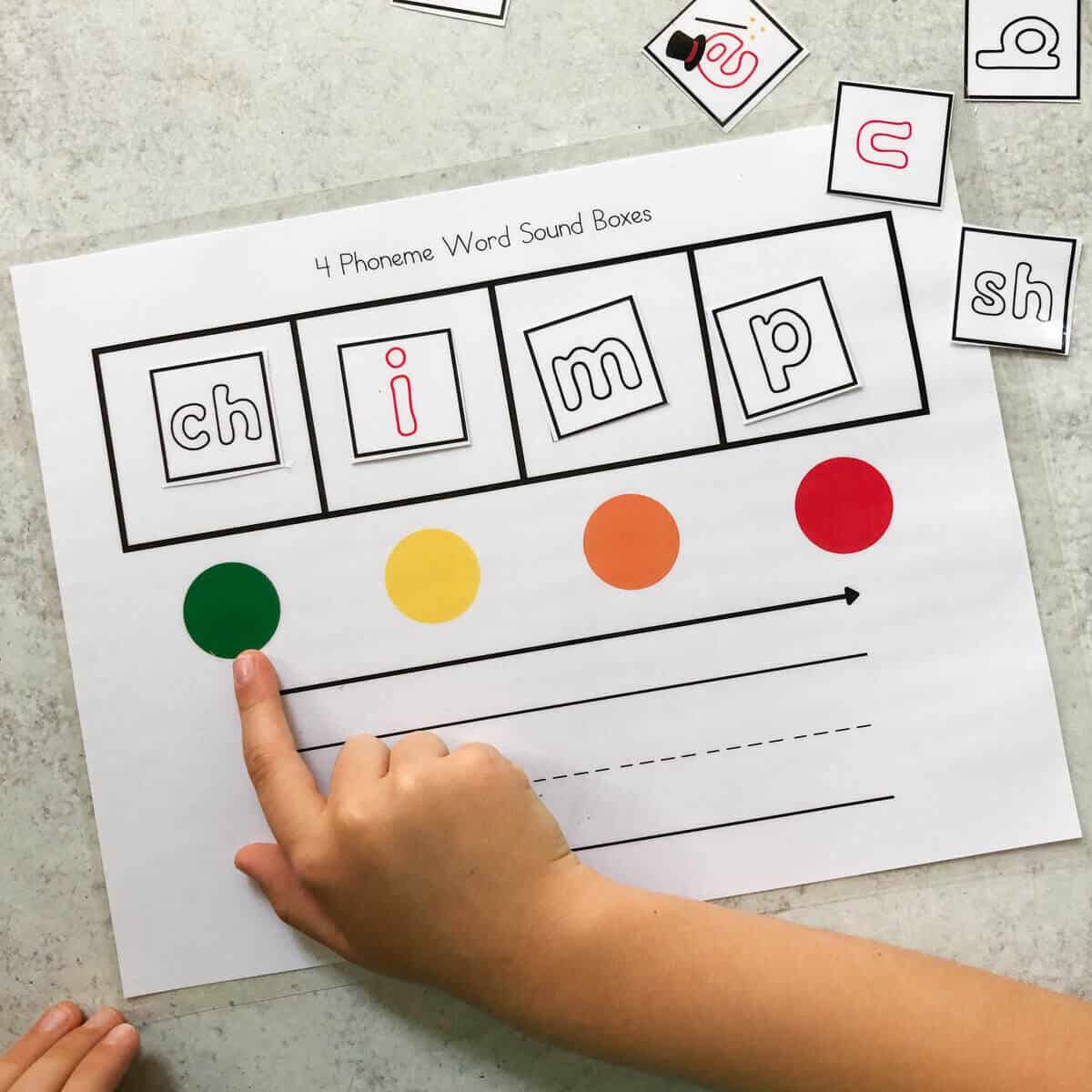 A child mapping the word "chimp" using Elkonin Boxes.