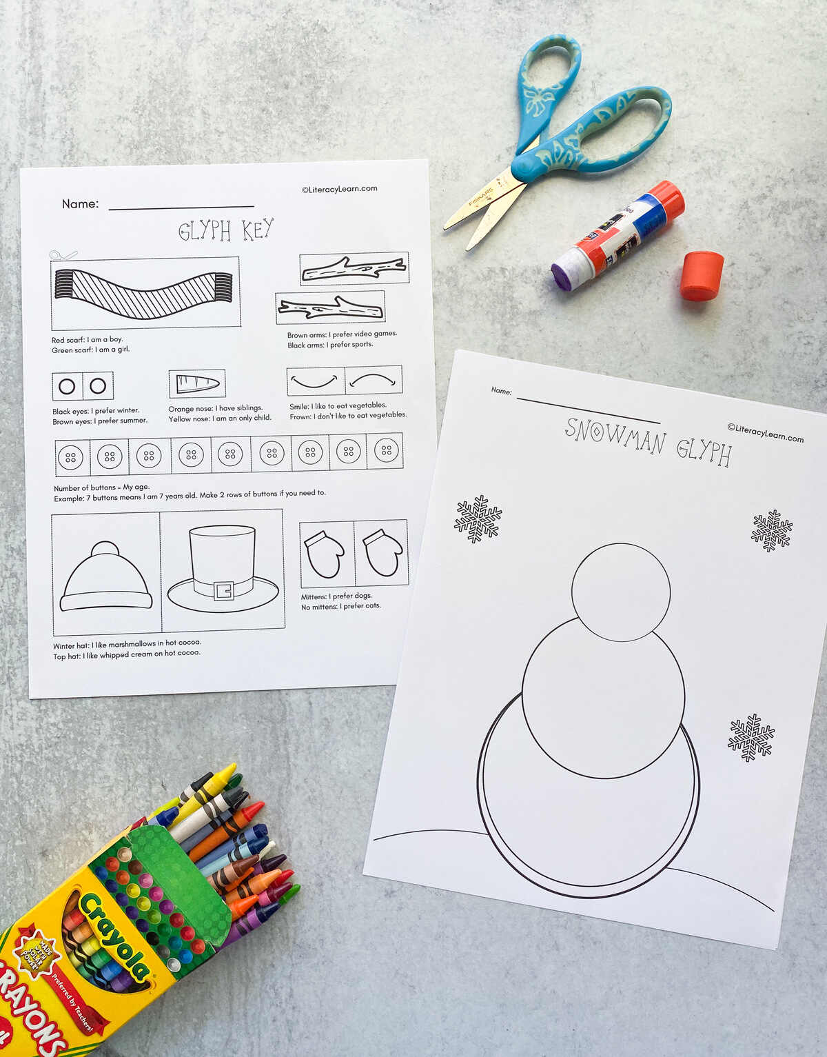 Printed snowman glyph and key printed beside crayons, glue stick, and scissors. 