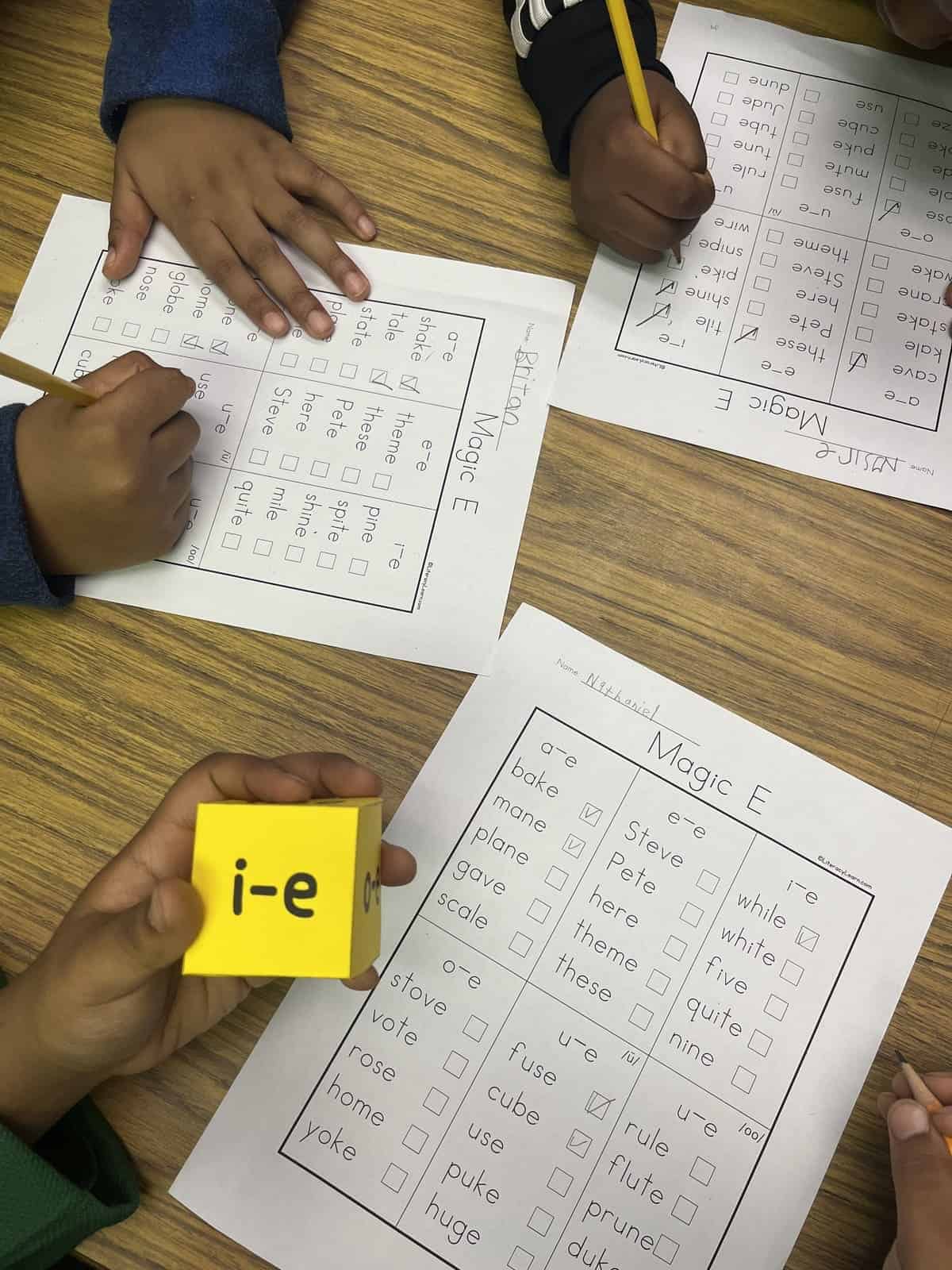 Students rolling the dice and marking the silent E words on the 3 worksheets.