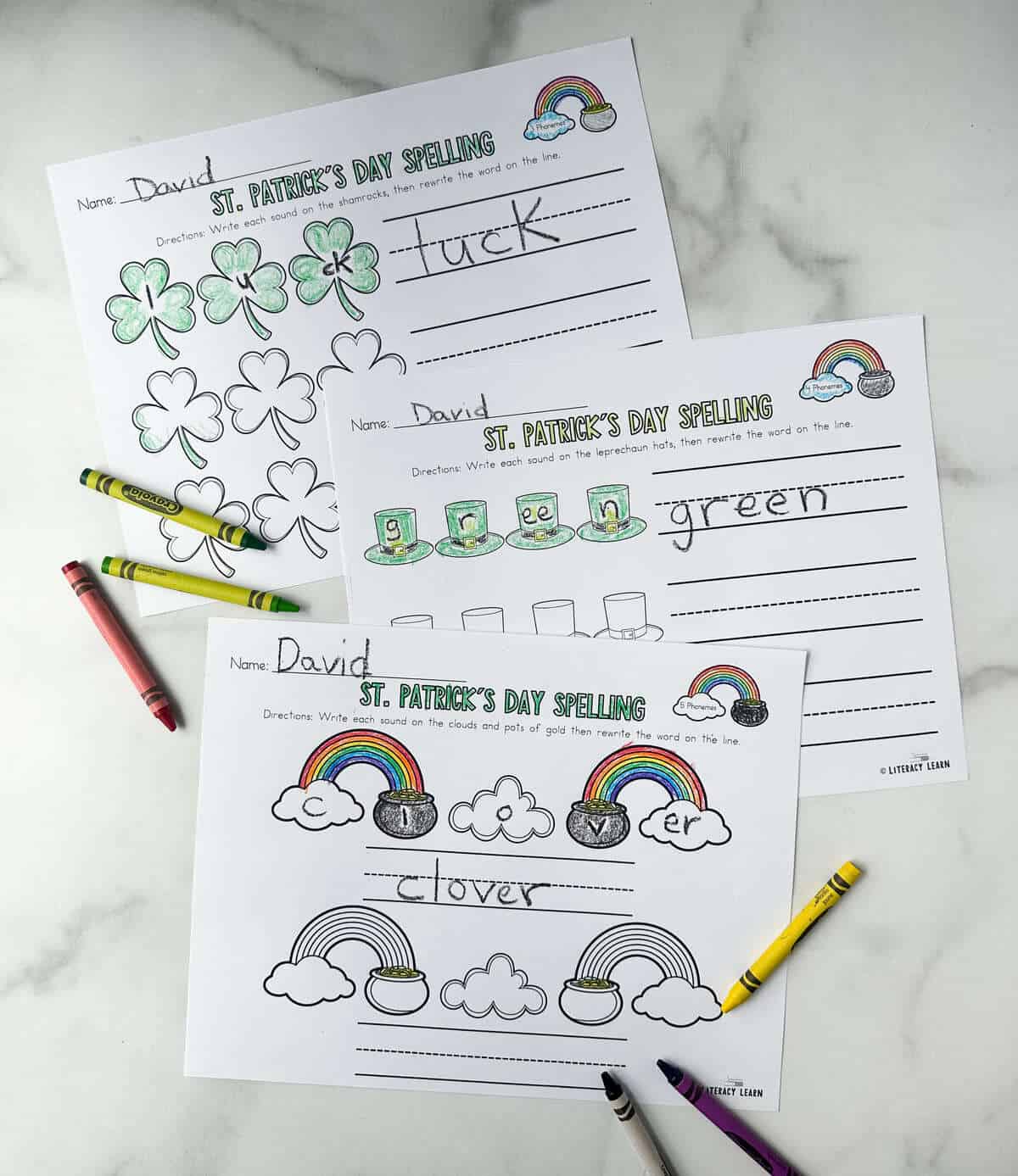 Three printed and colored St. Patrick's Day spelling worksheets with crayons. 