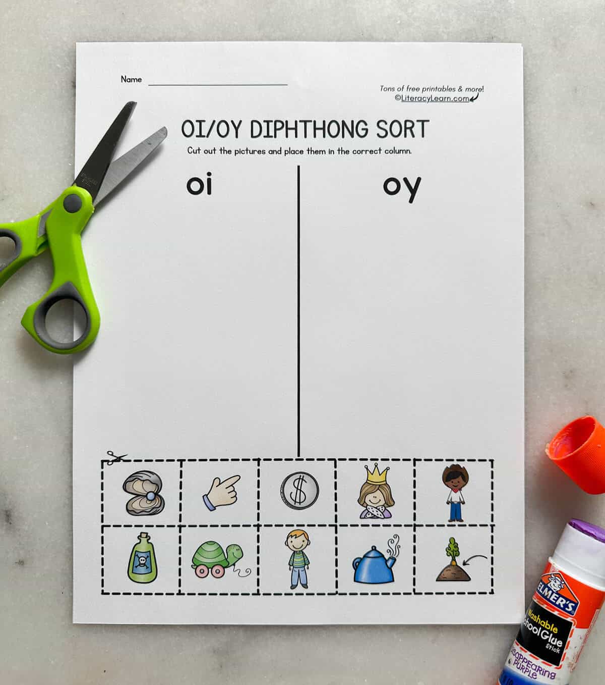 A printed oy and oi picture word sort with scissors and a glue stick. 