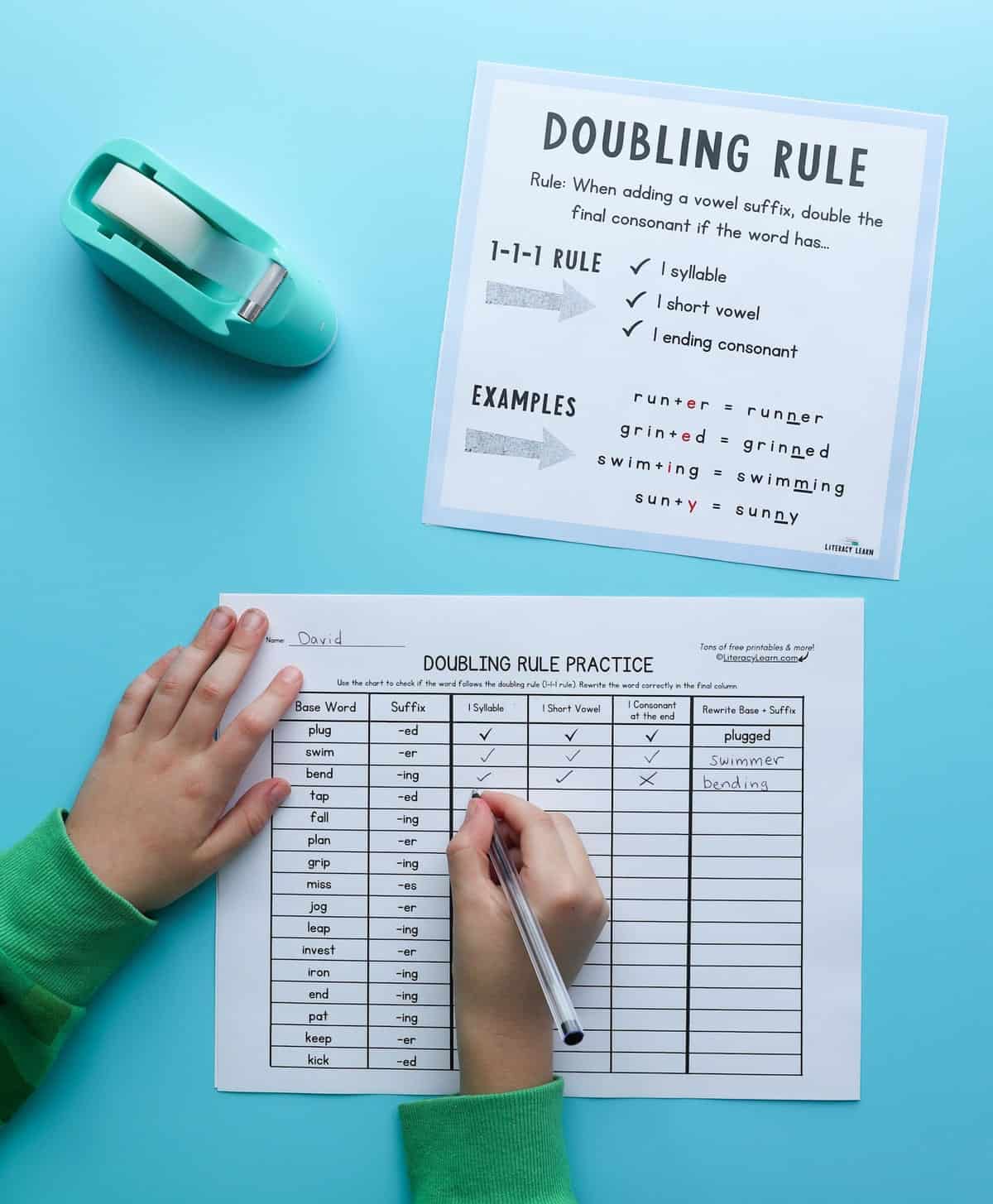 Photo showing child's hands completing the Doubling Rule worksheet along with the graphic for support.