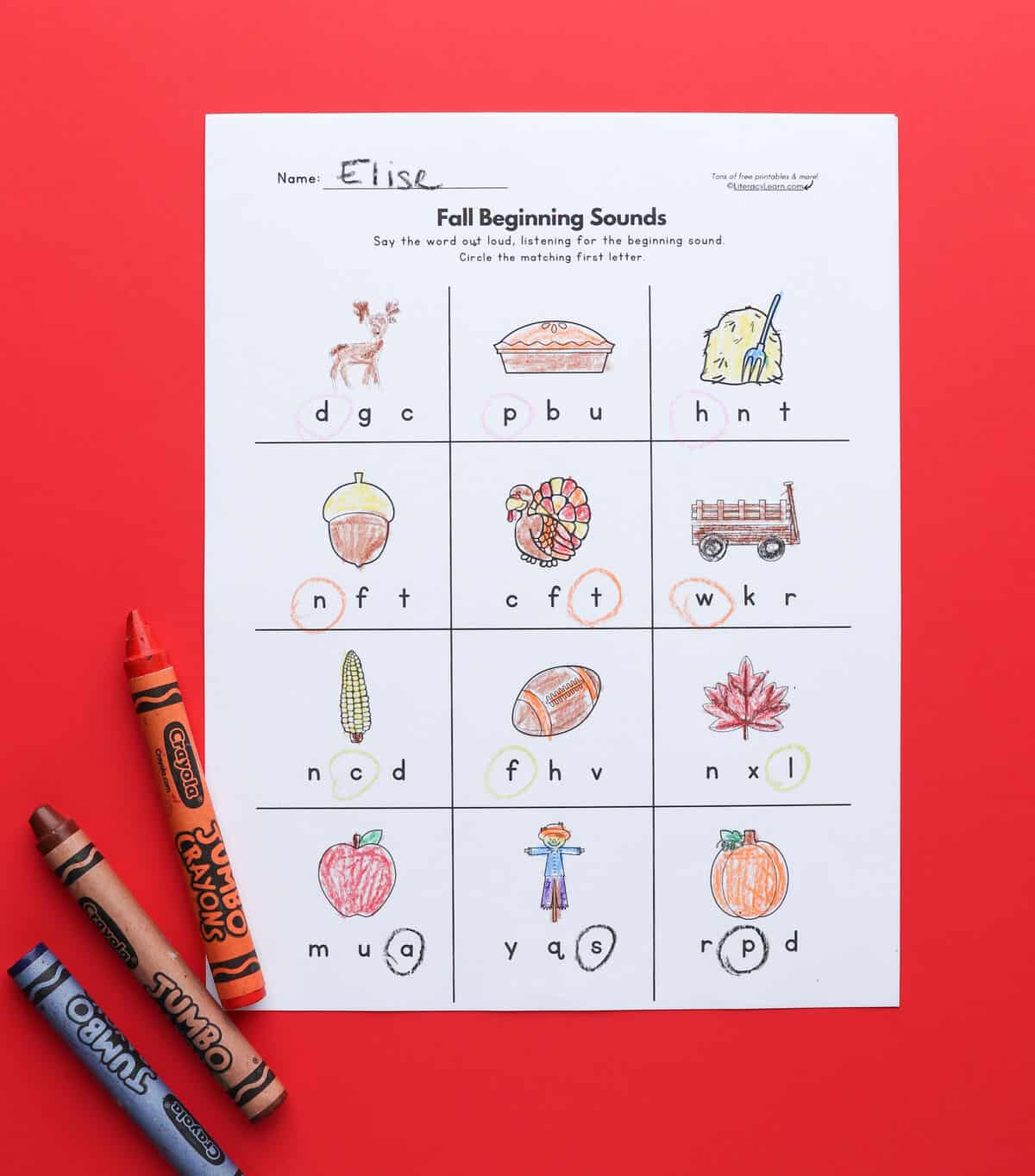 A printed fall-themed initial sounds worksheet on a red background.