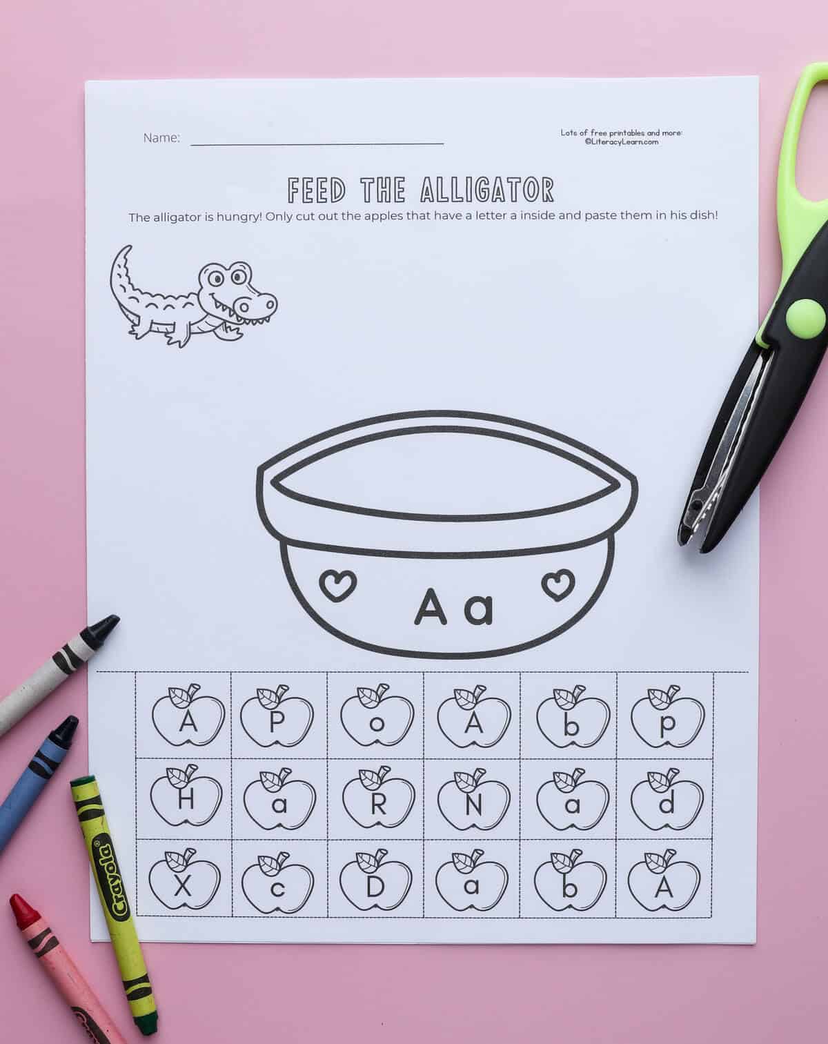 The printed "Feed the Alligator" worksheet with crayons and scissors. 