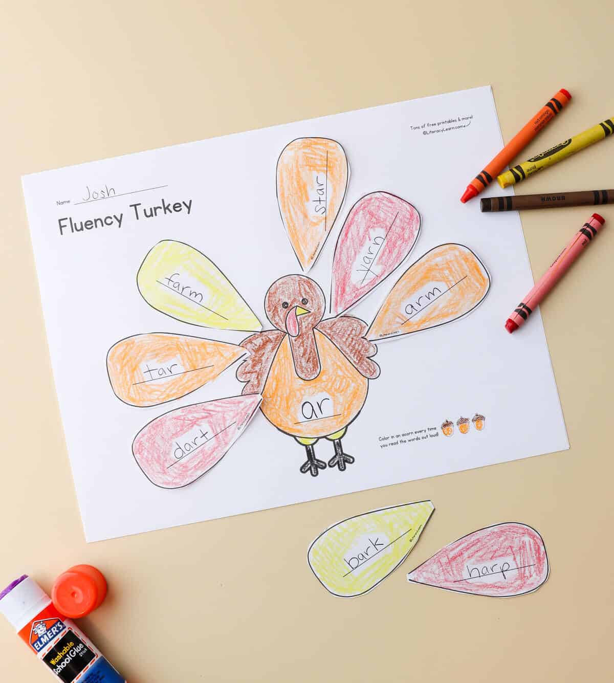 The printed fluency worksheet with "ar" fluency skill and crayons and a glue stick. 