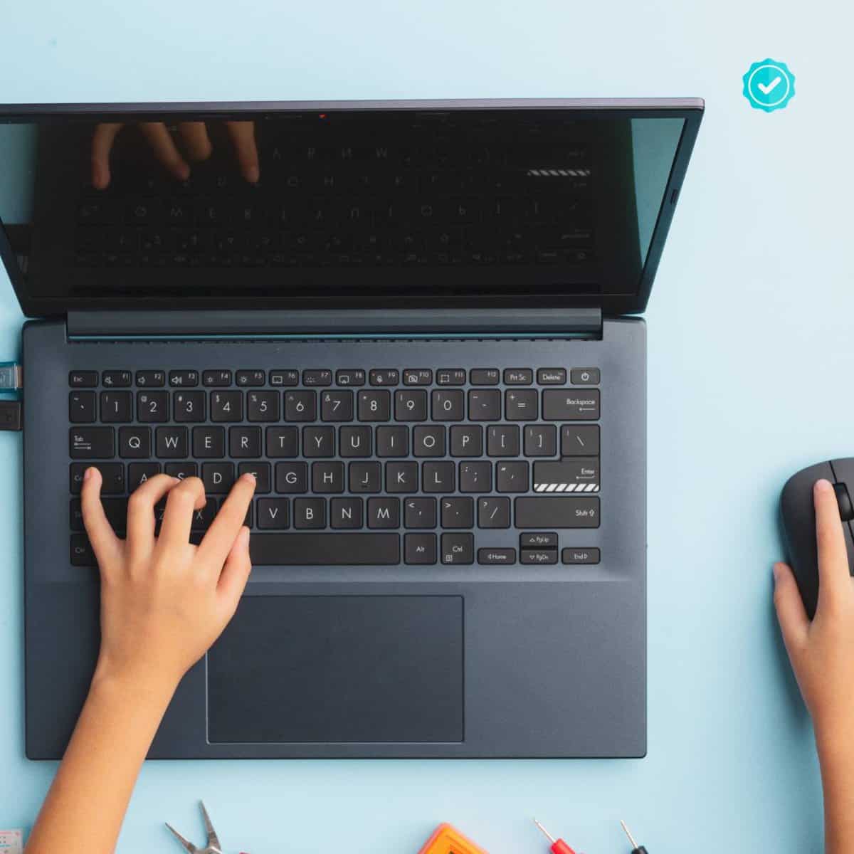 A child's hands working at a laptop.