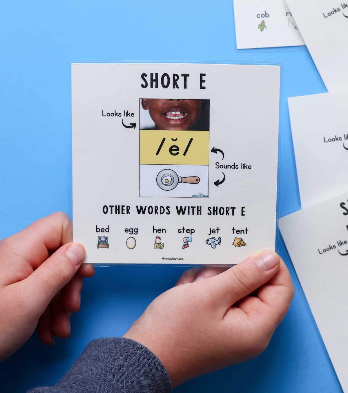 Graphic showing the short e sound with mouth articulation photo, anchor image, and word examples.