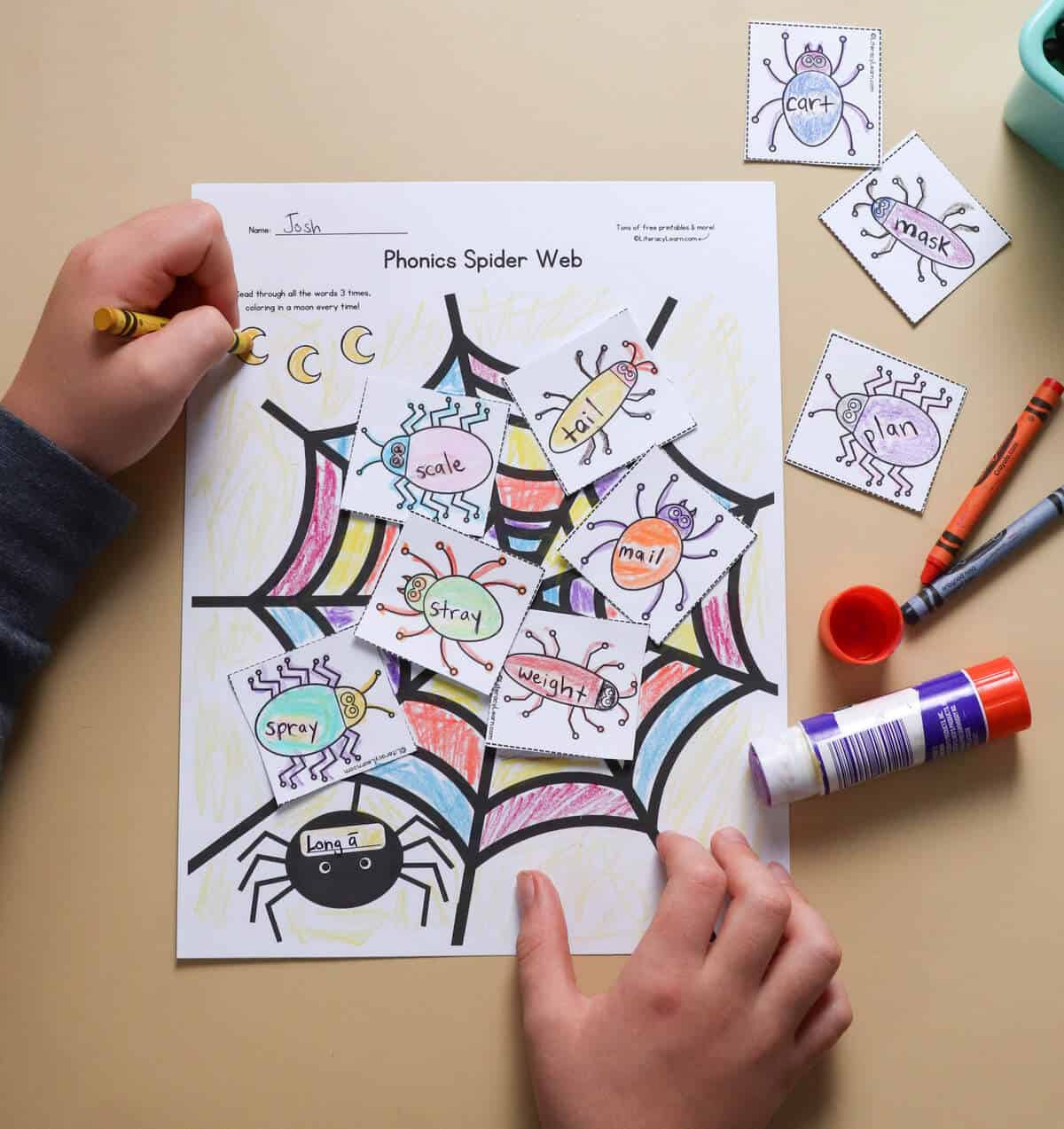 A child coloring in the spider web reading practice worksheet. 