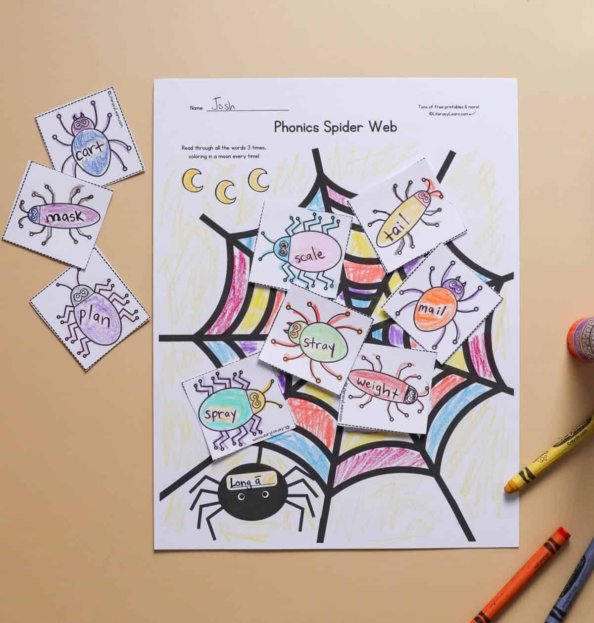 A completed phonics spider web worksheet with words written on bugs.