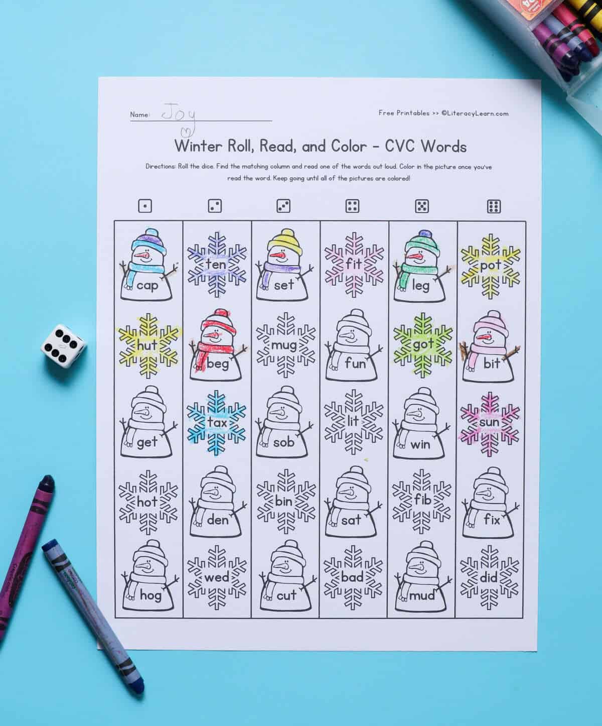 A printed CVC roll, read, and color worksheet with snowmen and snowflake graphics. 