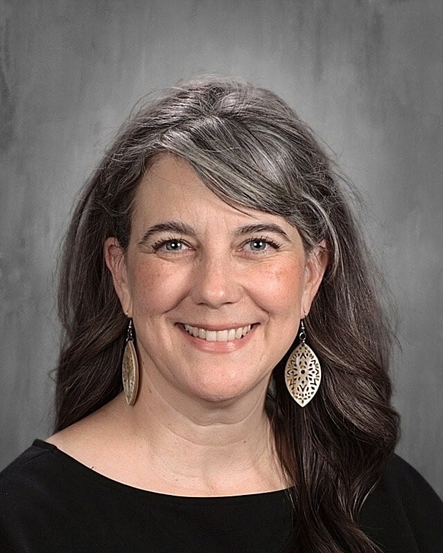 A headshot of a smiling woman.