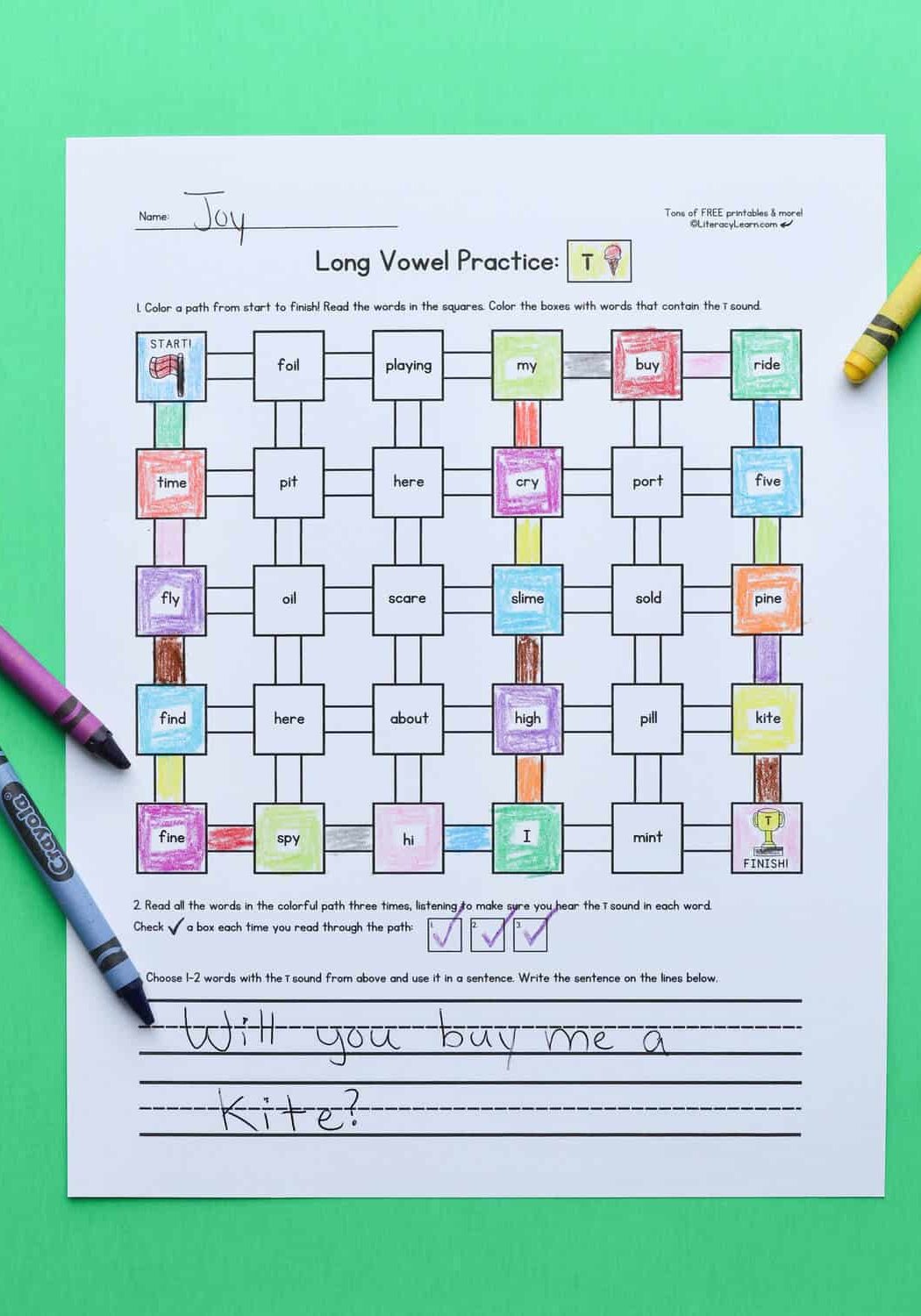 Long I words maze worksheet on a green background with crayons.